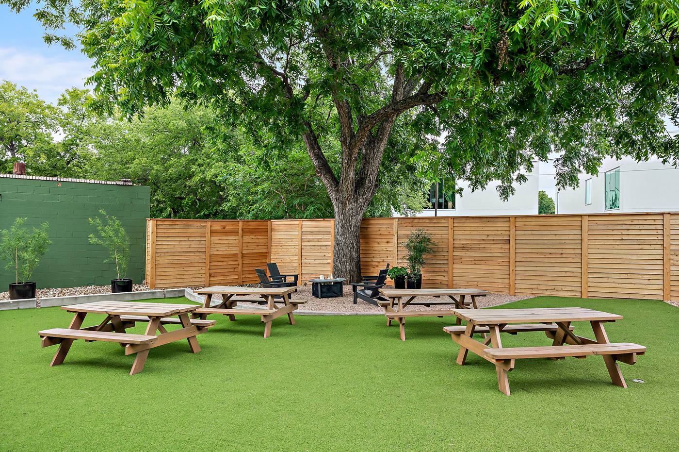 Turfed courtyard lawn with seating and shade umbrellas at Webber East